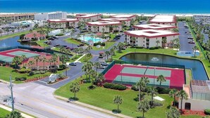 A resort with multiple buildings, a swimming pool, tennis courts, and a view of the ocean. - St Augustine Beach Condo just steps from the beach! (St. Augustine)