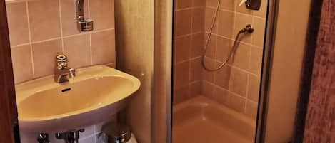 Une salle de bain avec une douche à parois de verre, un lavabo et un miroir.