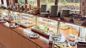 A buffet counter with various food items, plates, and utensils. - Heidehotel Soltauer Hof (Soltau)