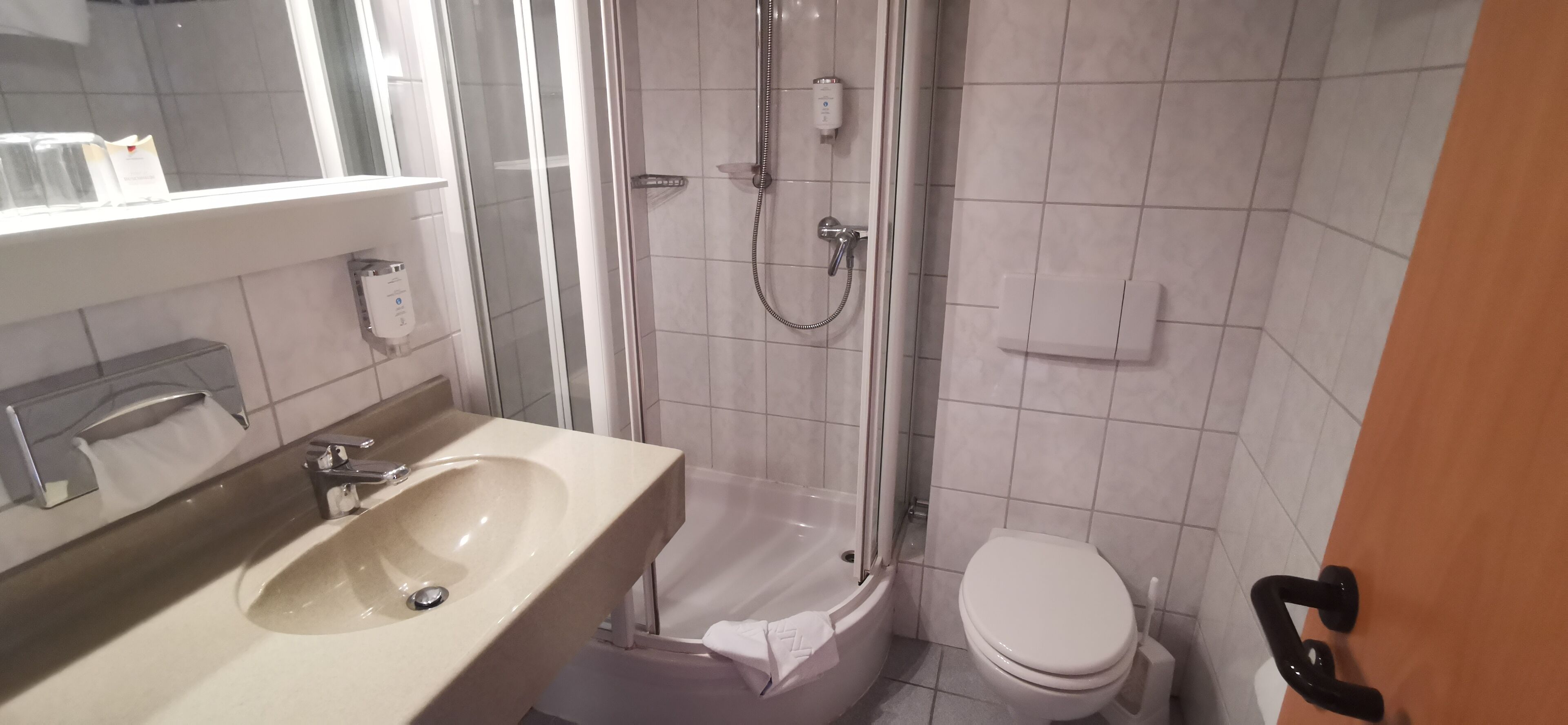 A bathroom with a sink, toilet, and glass-enclosed shower.