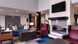 A modern living room with a fireplace, sofas, and a flat-screen TV. - Outdoor Pool. Free Breakfast. Cozy Queen Studio. (Lake Charles)