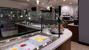 A buffet area with a glass barrier, ice trays, and various food items. - Outdoor Pool. Free Breakfast. Cozy Queen Studio. (Lake Charles)