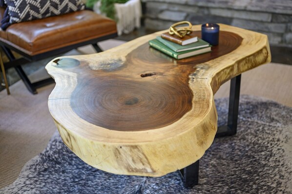 A wooden coffee table with a unique design, placed on a patterned rug.