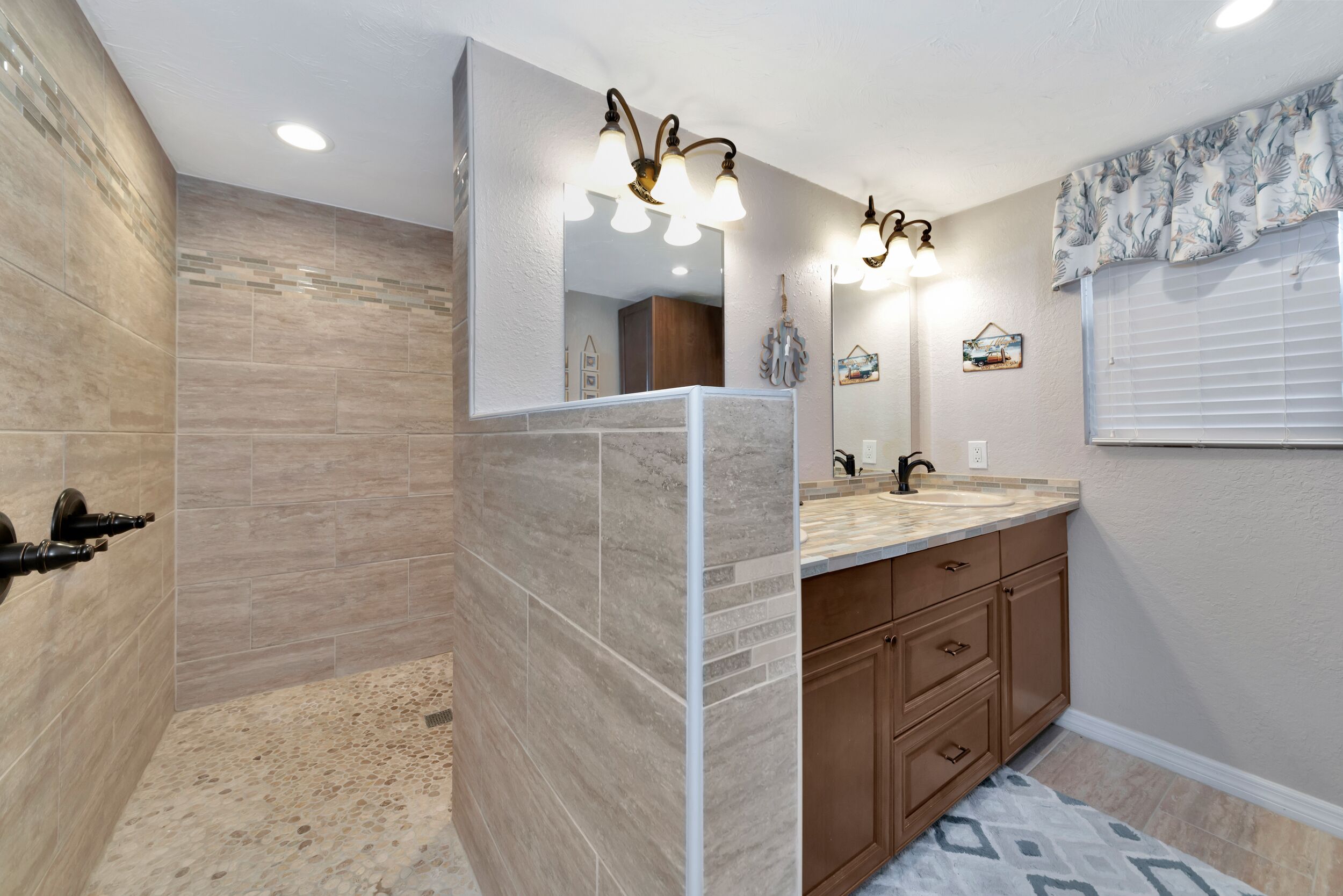 Une salle de bain avec une douche, un meuble-lavabo et un miroir.