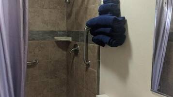 A bathroom with a shower, toilet, and sink.