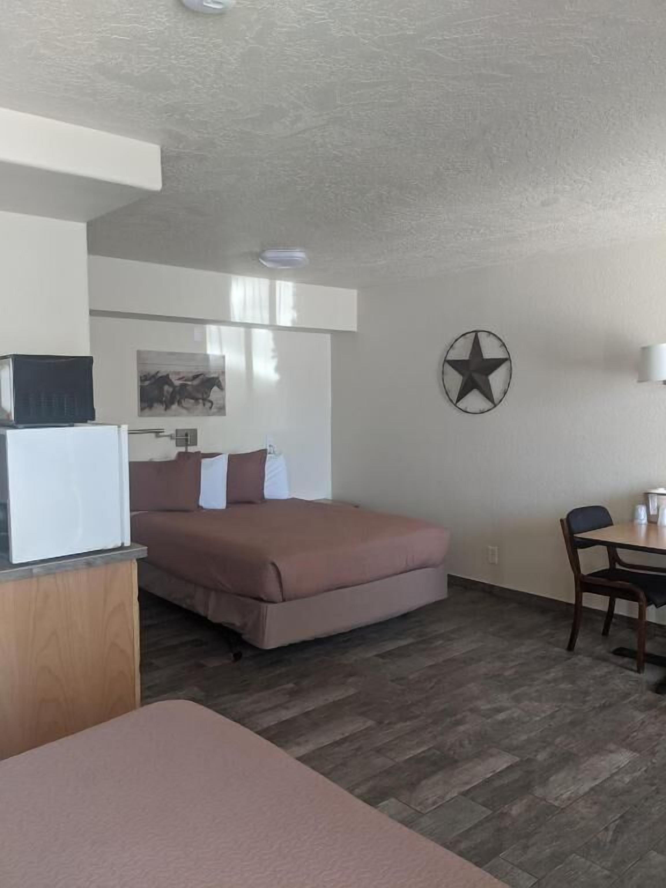 Una habitación con una cama, un escritorio y una silla. Hay una decoración con forma de estrella en la pared.