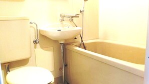 Un baño pequeño con inodoro, lavamanos y bañera.
