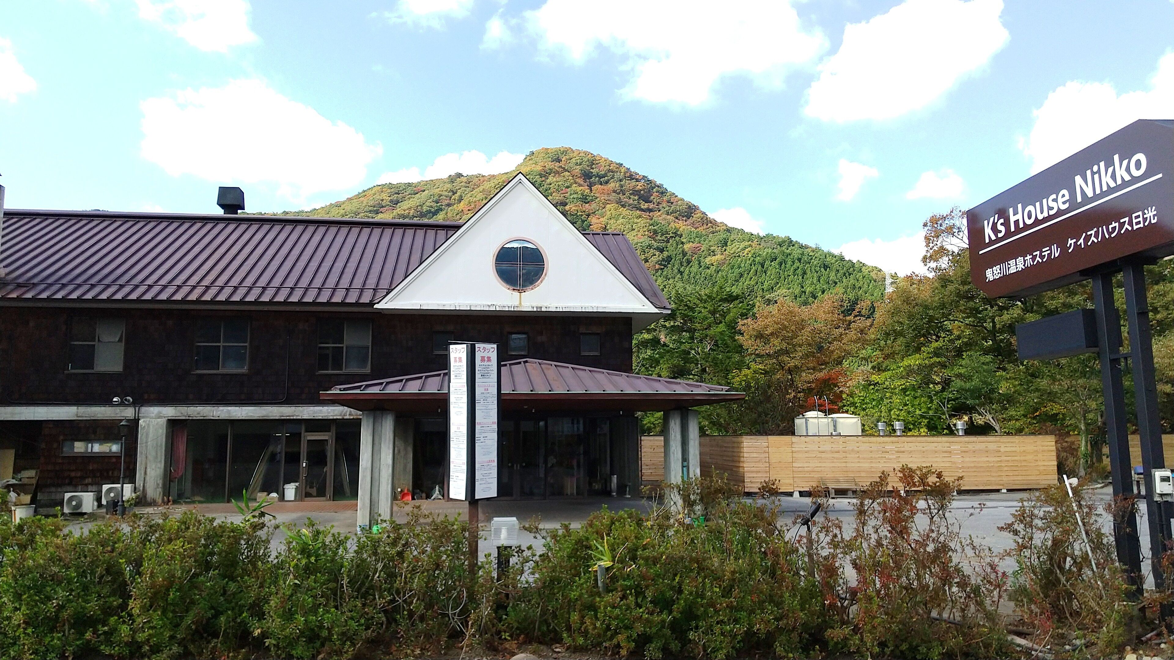 A building with a sign reading "K's House Nikko" and a mountain in the background.