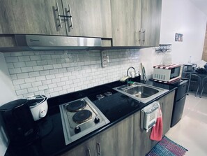 Kjøleskap, mikrobølgeovn, kjøkkenutstyr og spisebord