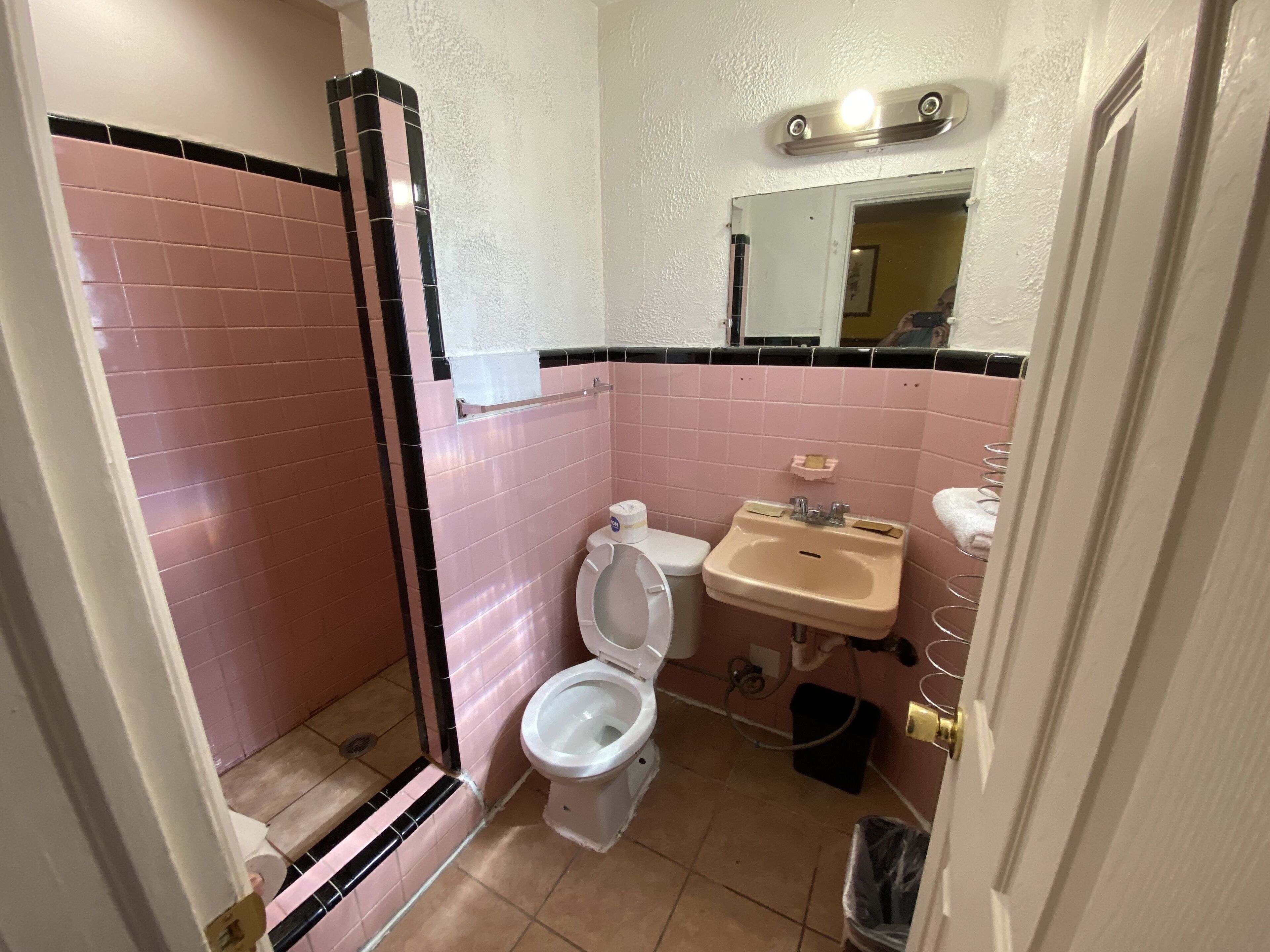 A bathroom with a toilet, sink, and shower.