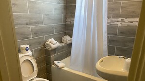 Une salle de bain avec des toilettes, une baignoire et un lavabo.