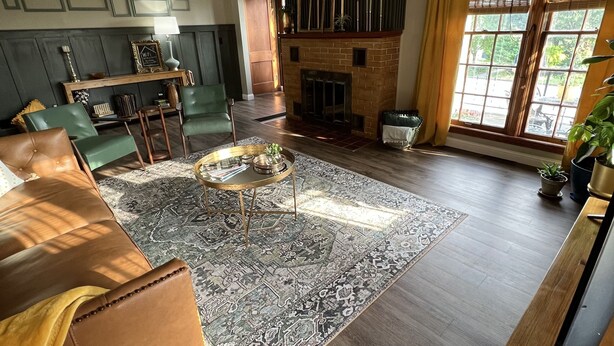 A spacious living room with a fireplace, leather sofa, and a large rug. - Mid-Century Modern Home (Washington)