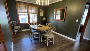 A dining area with a wooden table and chairs, a chandelier, and a globe on a stand. - Mid-Century Modern Home (Washington)