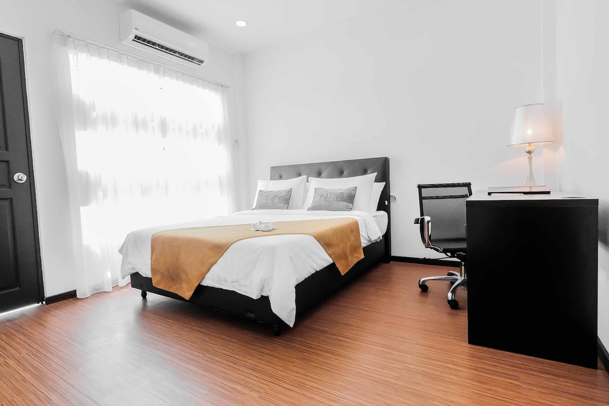 Ein Hotelzimmer mit Bett, Schreibtisch und Stuhl.