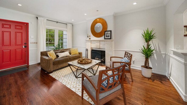 A living room with a red door, a fireplace, a round mirror, and a potted plant. - Stylish villa in the heart of all fun in Miami (Miami)