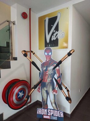 Una pared con un cartel grande de Iron Spider, un letrero del Hotel Vito, y un blanco con flechas.