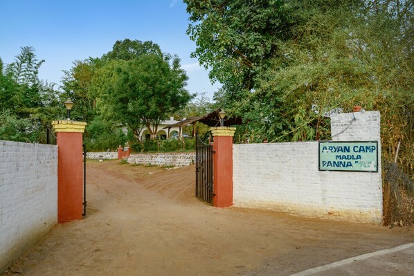 A gated entrance to a camp with a sign reading "Aryan Camp Madla Panna."