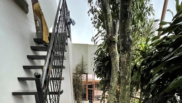 Eine Treppe führt zu einem Gebäude mit weißer Außenwand und einem Metallgeländer.