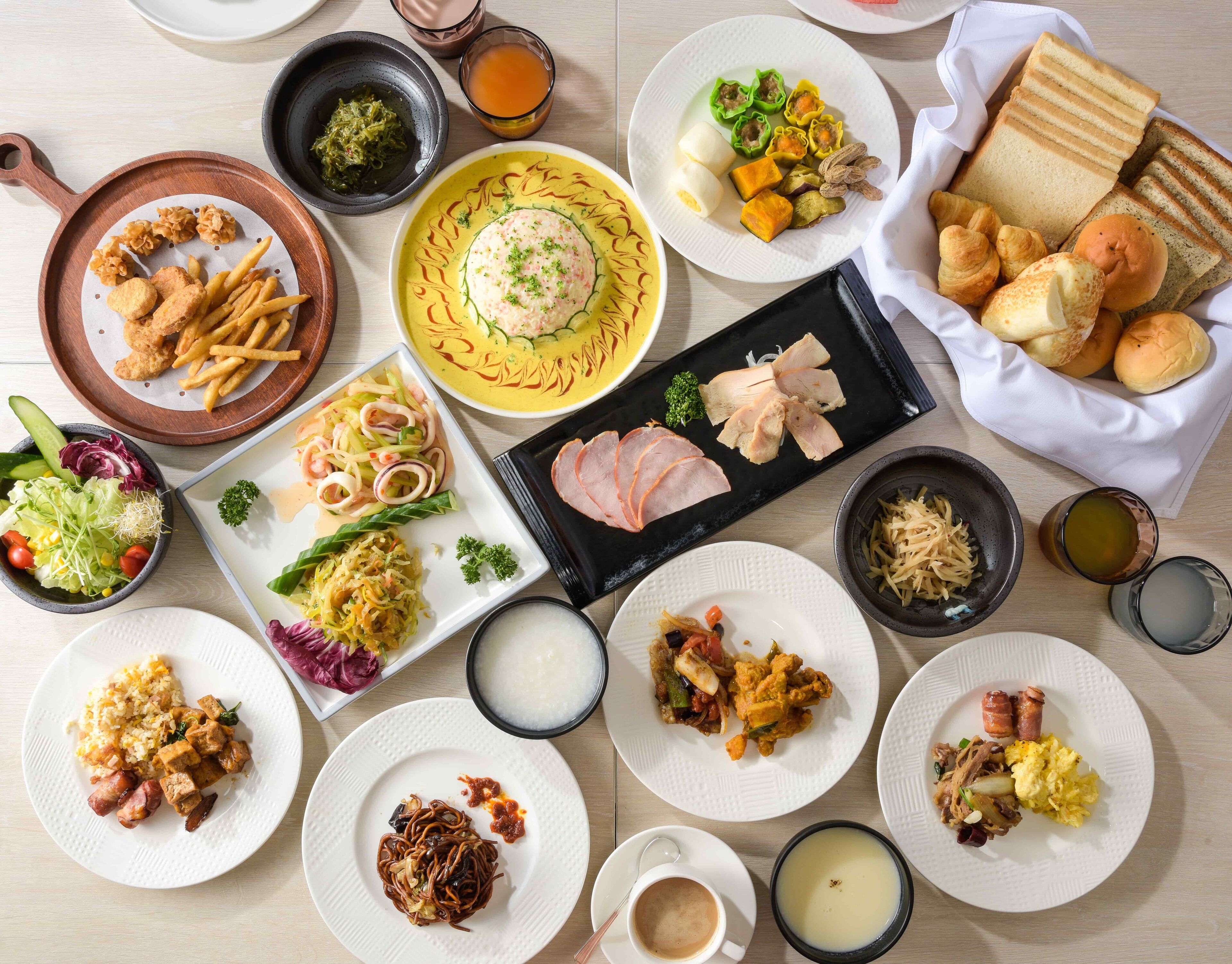 A variety of dishes including fried items, noodles, and bread, suggesting a diverse meal selection.