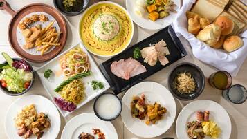 A variety of dishes including fried items, noodles, and bread, suggesting a diverse meal selection.