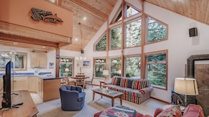A spacious living room with a large window, a fireplace, and a cozy seating area. - 75sl - 2-bdrm - Loft - Sleeps 6 - Wifi - Pets Ok (Deming)