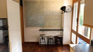 Una cocina con un mapa grande en la pared, un reloj y dos taburetes.