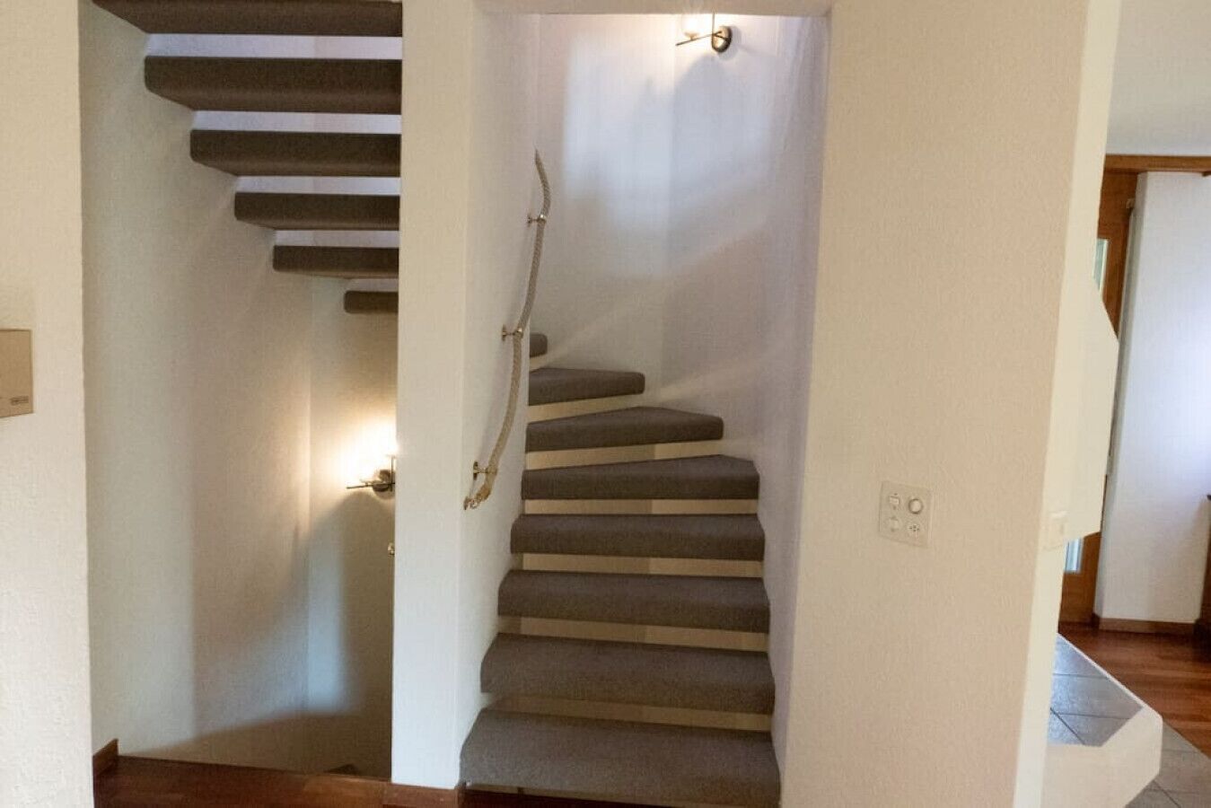 A staircase with carpeted steps leading to a landing.