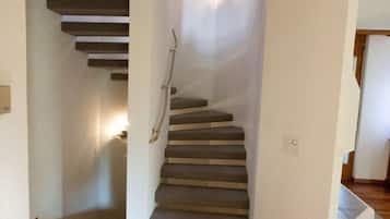 A staircase with carpeted steps leading to a landing.