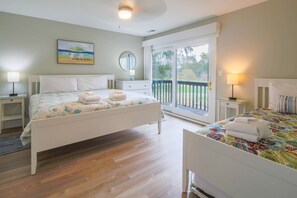 Cozy retreat with a large bed, nightstand, and dresser, offering a view of the outdoors.