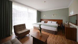 Una habitación de hotel con dos camas, un sofá, un escritorio y una mesita de café.