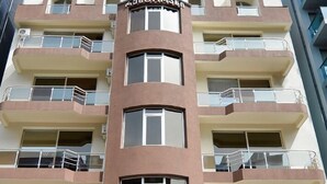 Un edificio de varios pisos con balcones y un letrero que dice "SOM'S AURA".