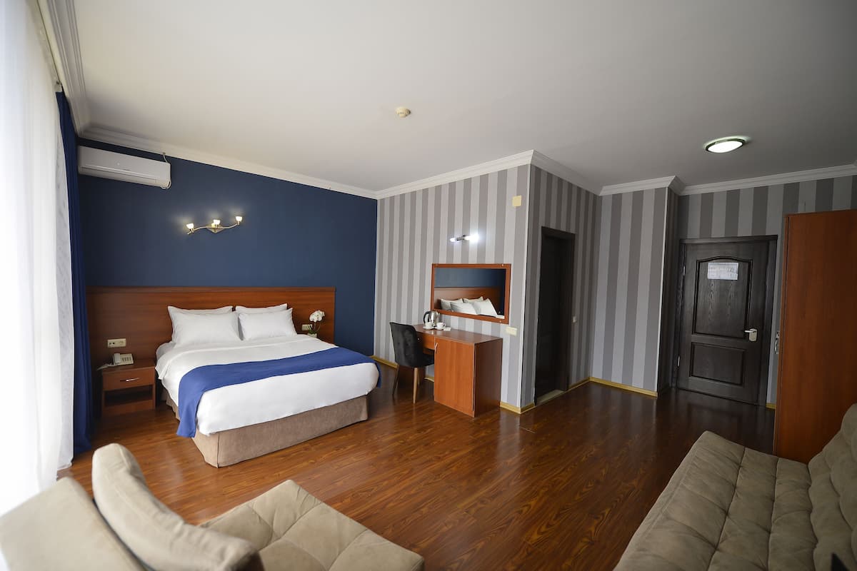 Una habitación de hotel con cama, escritorio, silla y puerta.