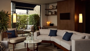 Una sala de estar moderna con un sofá seccional, una mesa de centro y un comedor con una silla y una mesa.