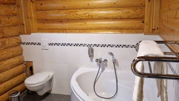 A bathroom with a white bathtub, a toilet, and a shower.