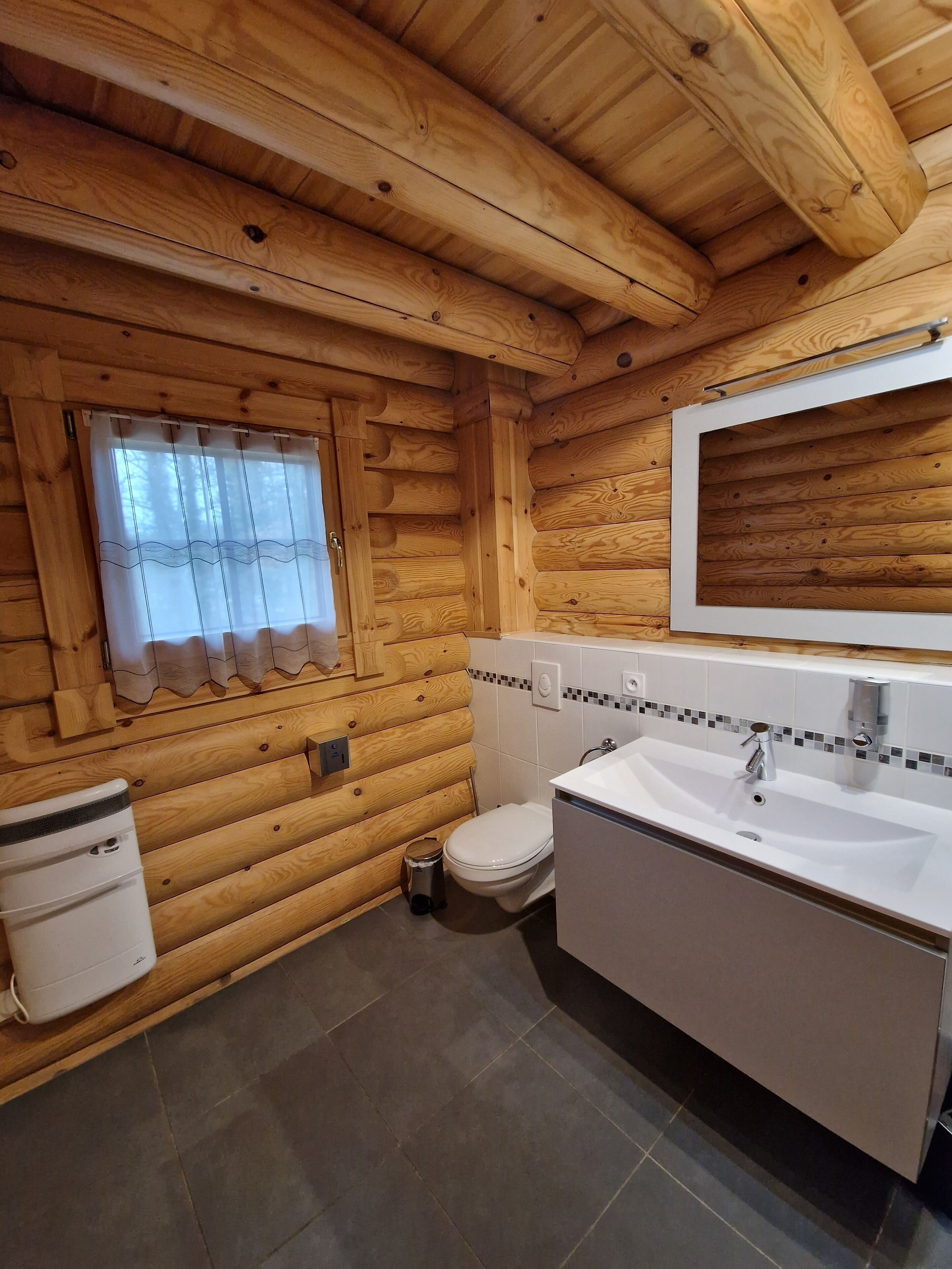 Puisesta mökistä löytyy kylpyhuone, jossa on wc, pesuallas ja ikkuna.