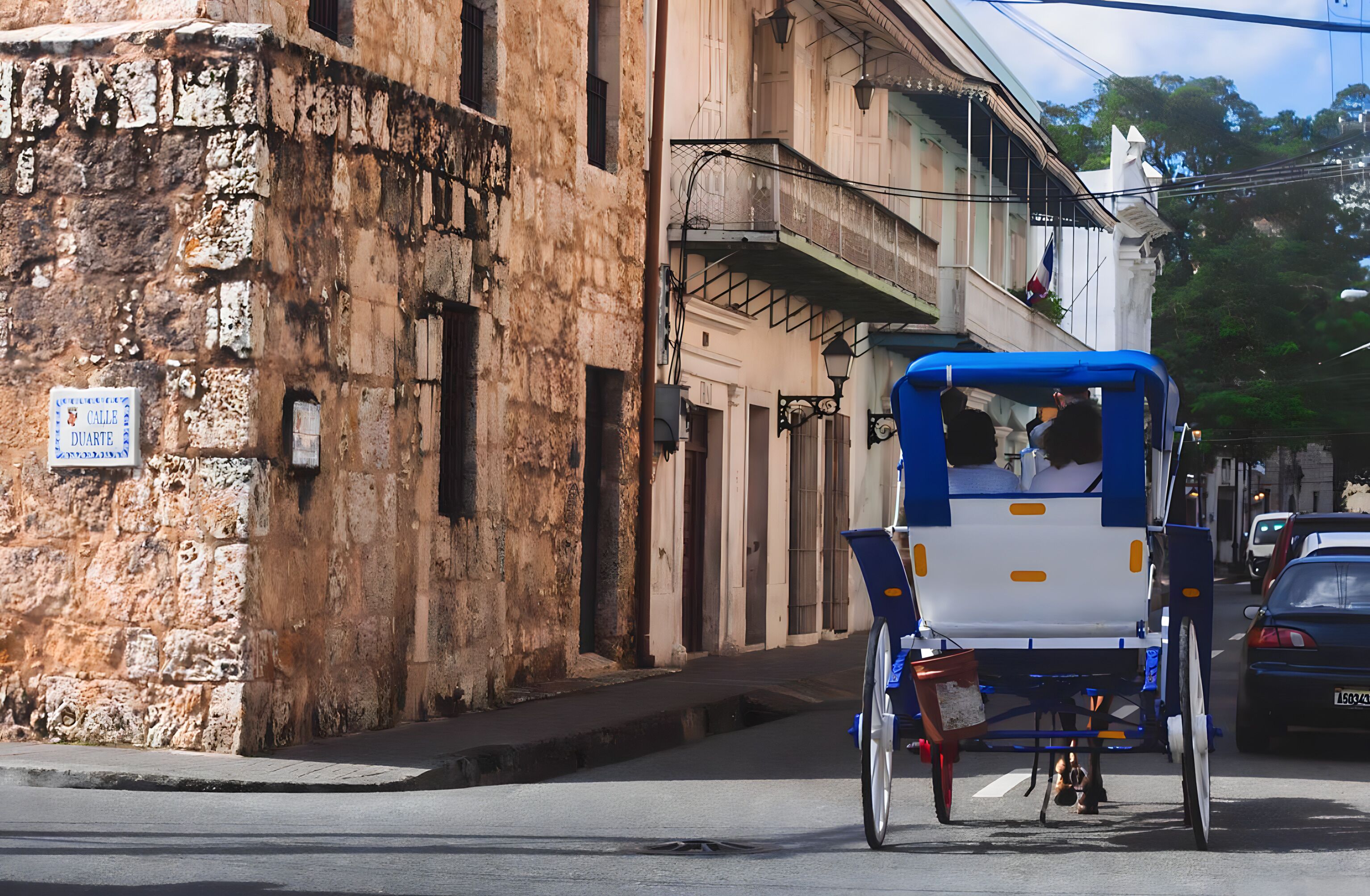 A street scene with a traditional rickshaw parked on the side of the road.