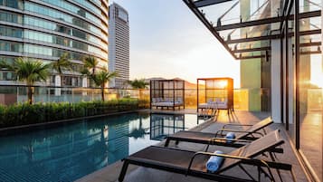 Una piscina al aire libre, sillones reclinables de piscina