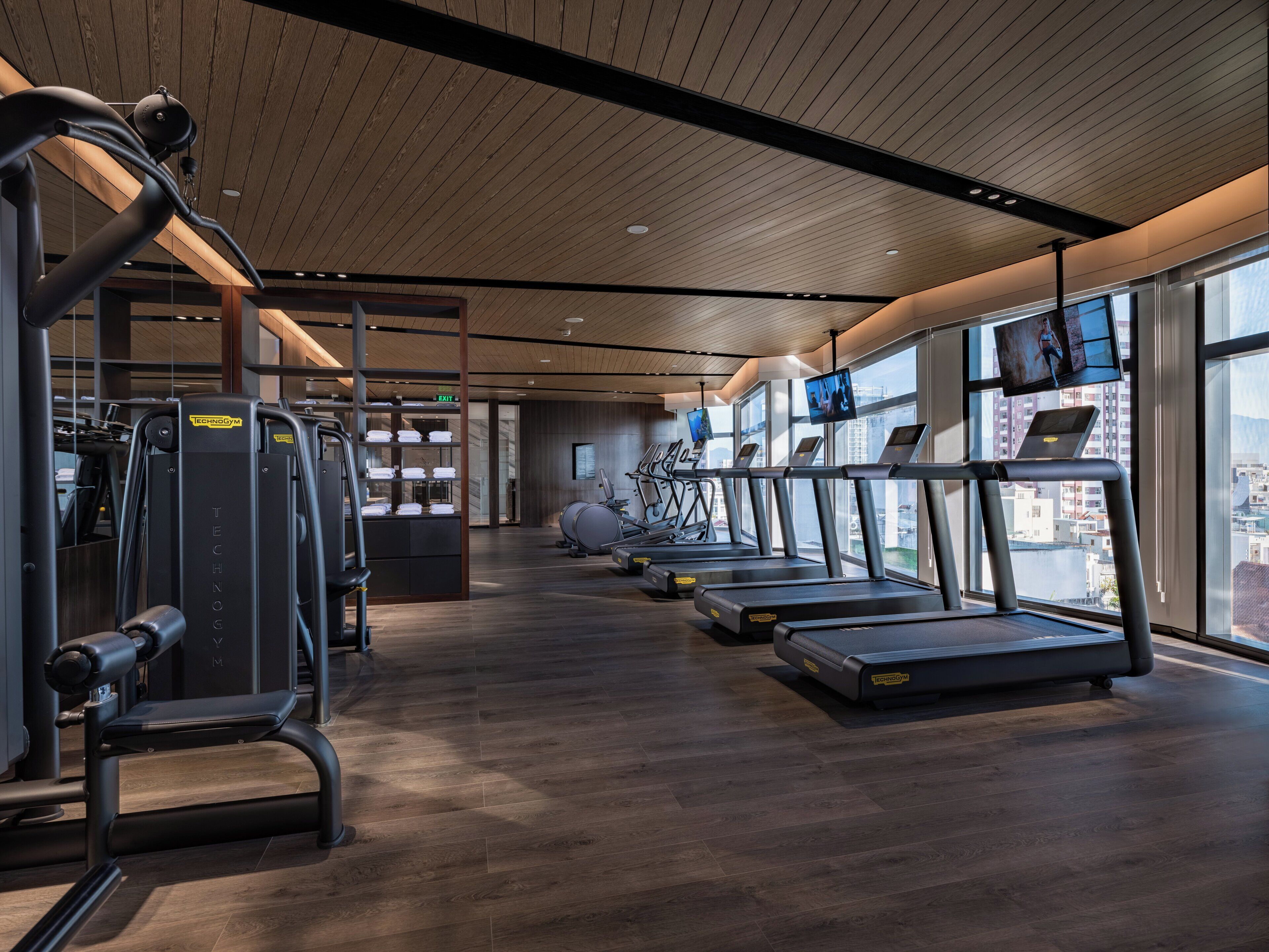 Un gimnasio moderno con cintas de correr, máquinas de pesas y pelotas de ejercicio.