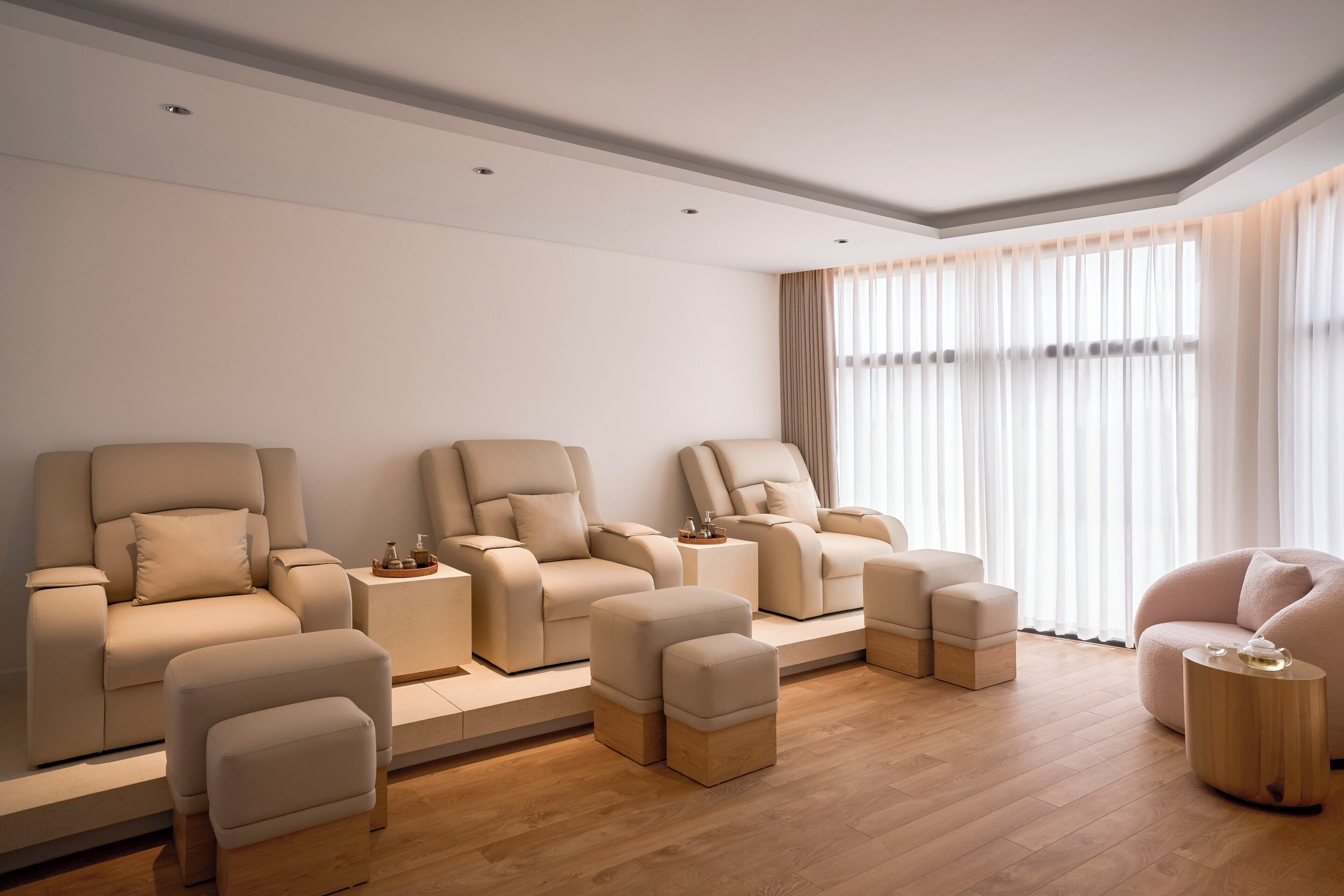 A modern living room with a sofa set, ottomans, and a coffee table.