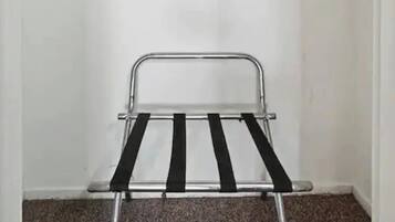 A room with a metal drying rack and wooden hangers on a wall-mounted rack.
