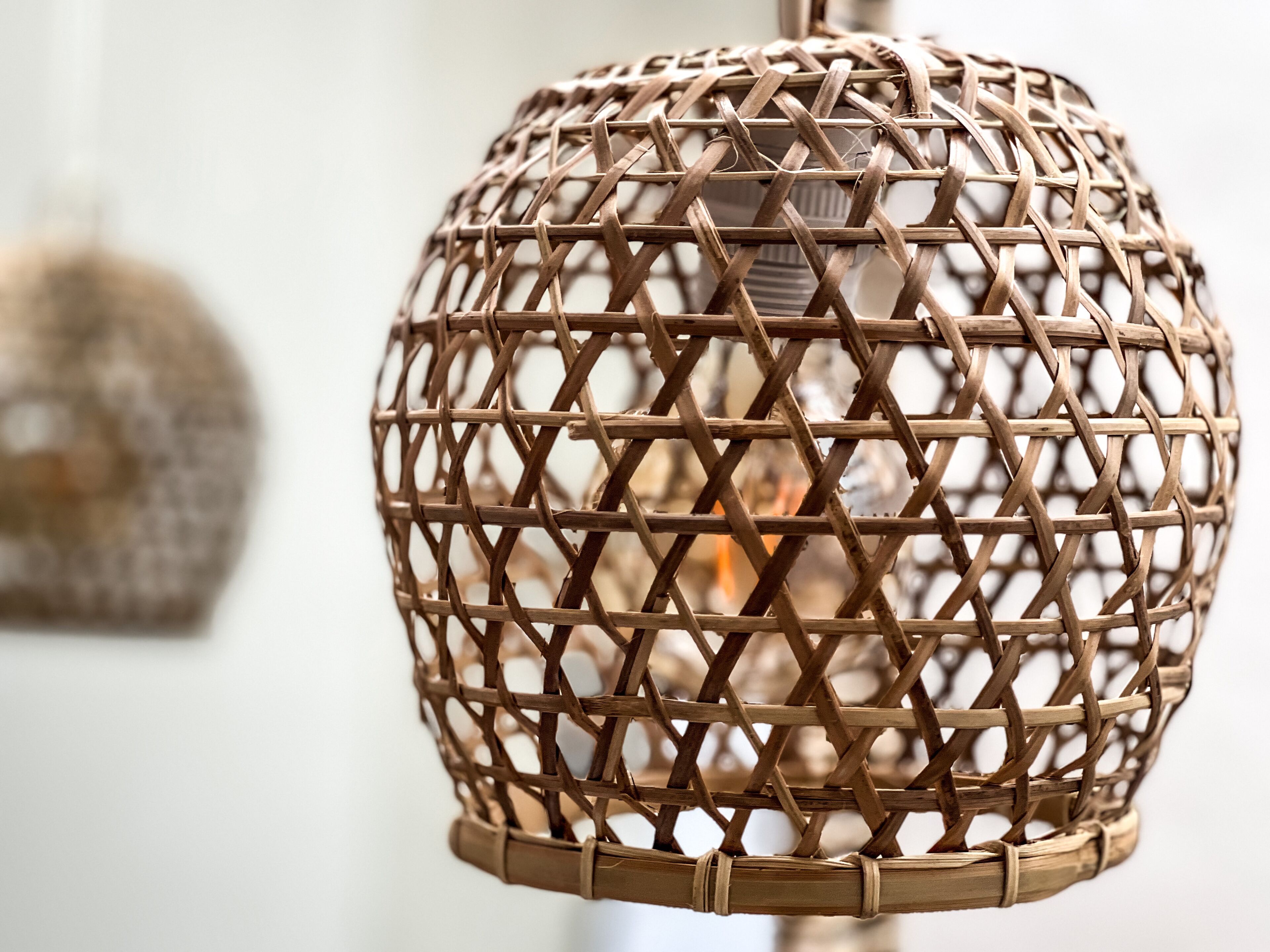A wicker lamp with a spherical design and a woven pattern.