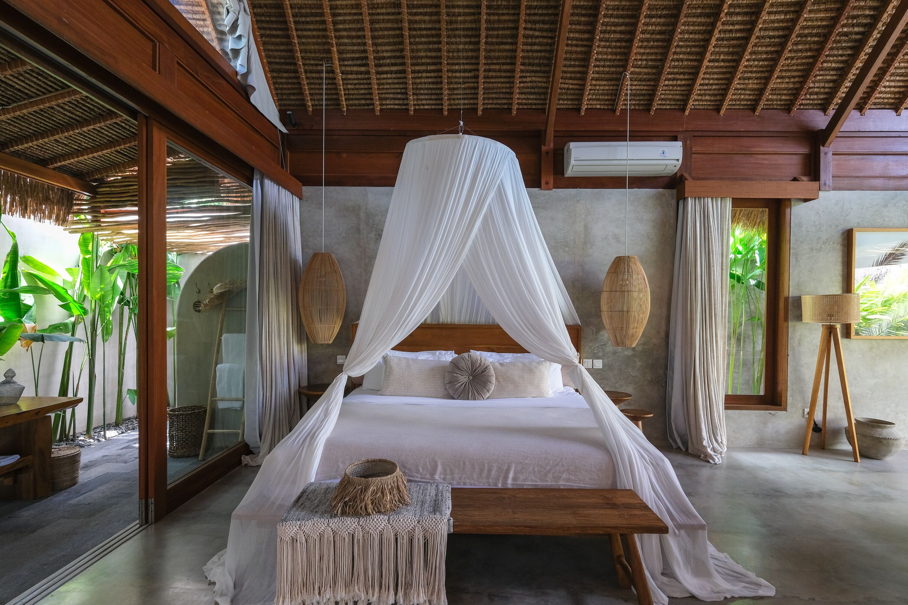 Amplio dormitorio con cama con dosel, muebles de madera y vista a zonas verdes.