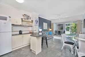 Enjoy cooking and dining in this well-equipped kitchen and dining area, featuring a range, microwave, and coffee maker.