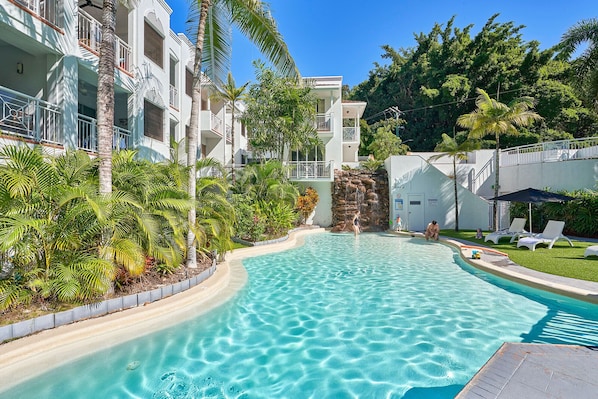 Relax by the pool surrounded by lush vegetation and modern architecture.