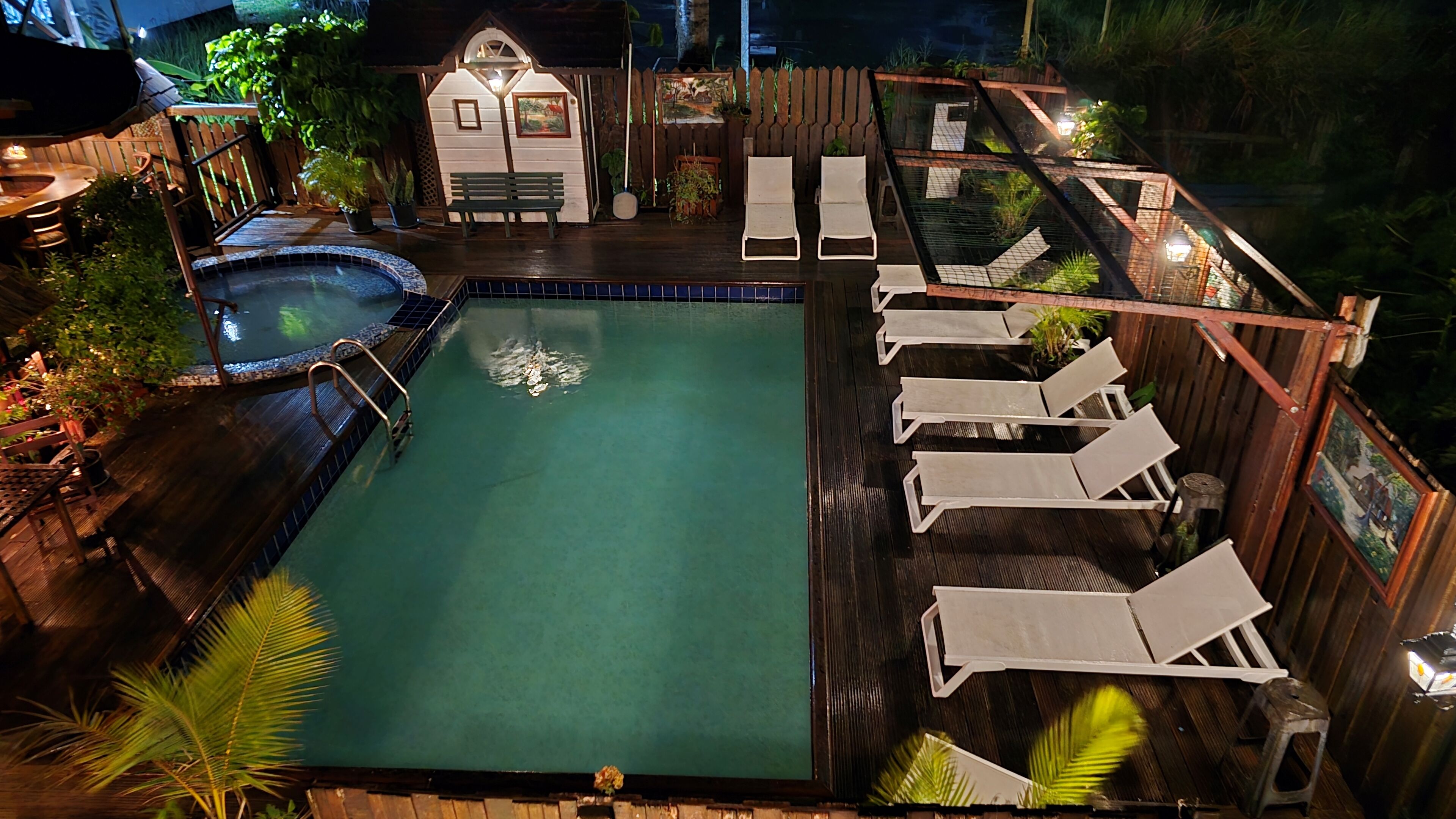 A swimming pool with lounge chairs and a small deck area.