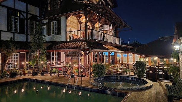 A two-story building with a pool, outdoor seating, and a balcony. - Greenheart Boutique Hotel (Paramaribo)