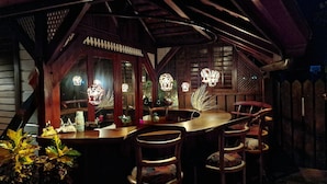 A cozy wooden cabin with a bar area, featuring rustic decor and warm lighting. - Greenheart Boutique Hotel (Paramaribo)