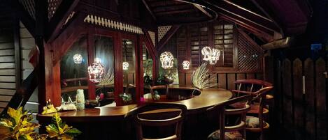 A cozy wooden cabin with a bar area, featuring rustic decor and warm lighting.