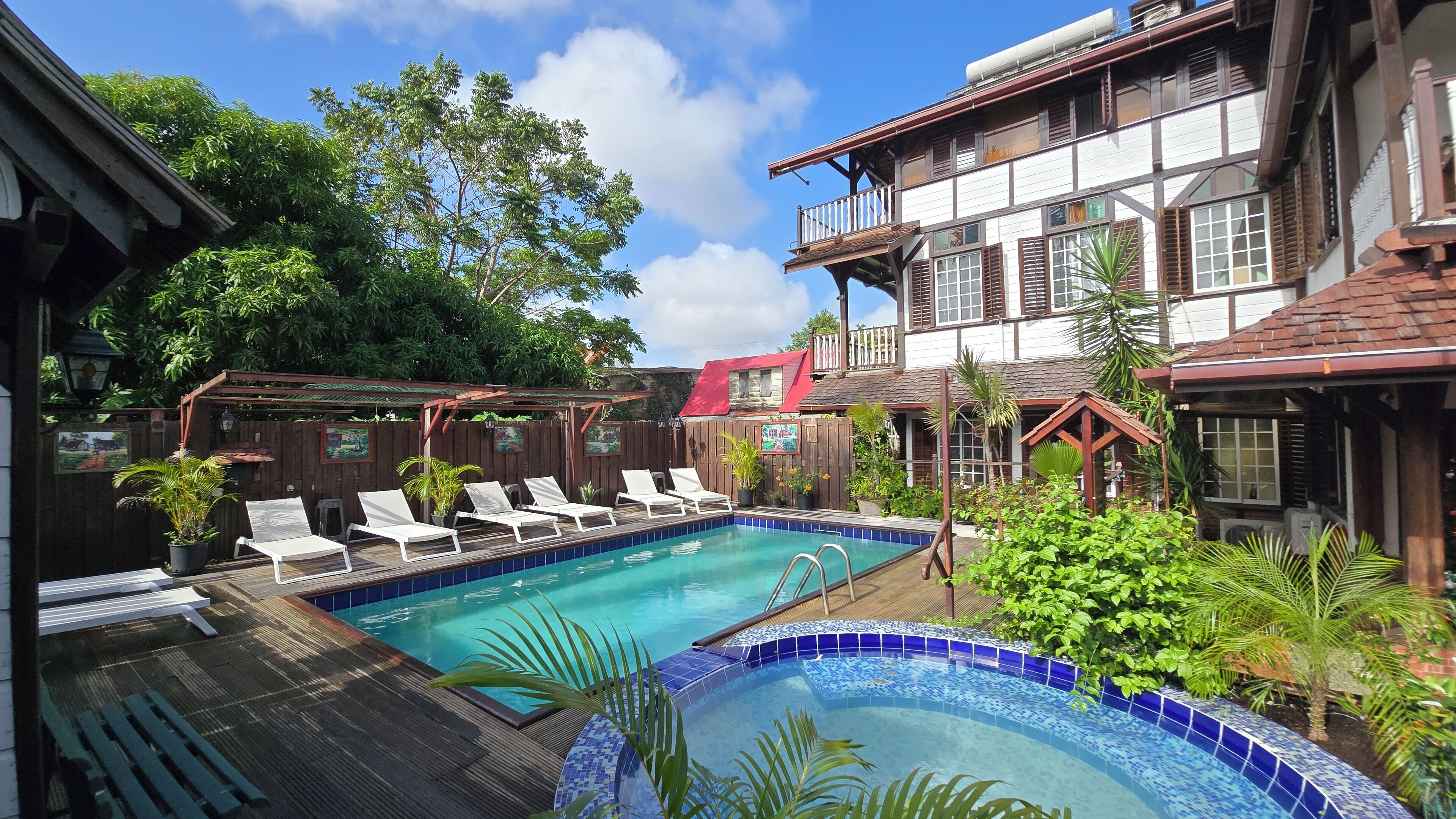 A pool area with lounge chairs and a wooden deck.