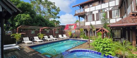 A pool area with lounge chairs and a wooden deck.